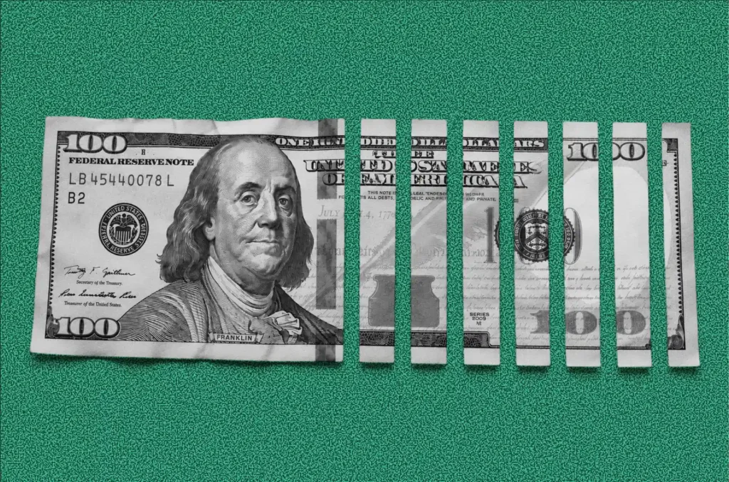 Half-shredded hundred-dollar bill illustrating the cost of choosing the wrong design firm